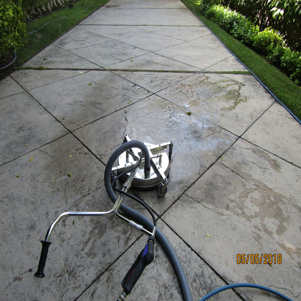 Professional surface-cleaning equipment on a residential concrete driveway